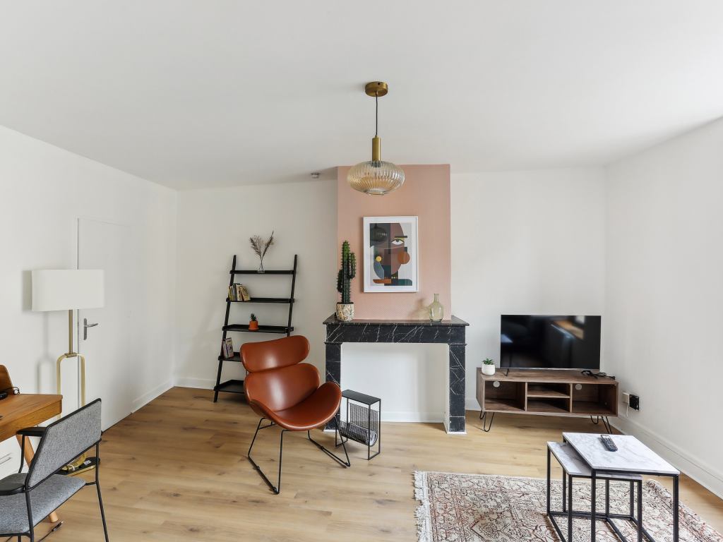 Pièce de vie avec parquet et cheminée en marbre noir