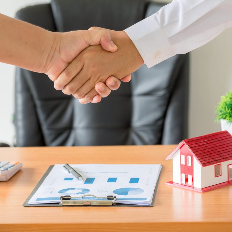 Side view hands of agent and client shaking hands after signed contract buy new apartment.