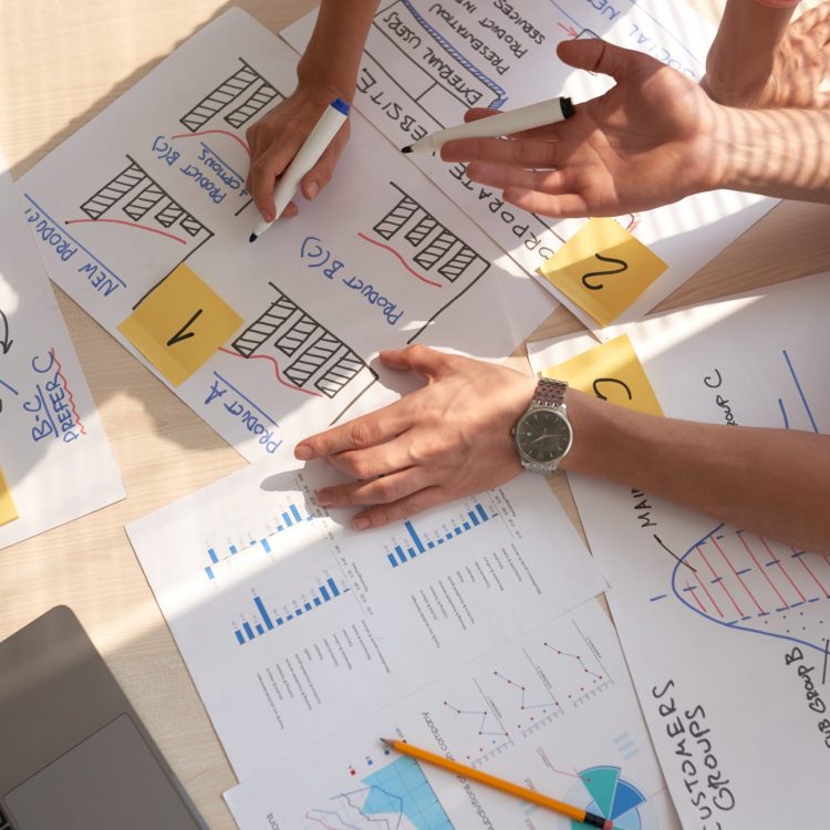 Business people discussing charts and diagrams, view from above